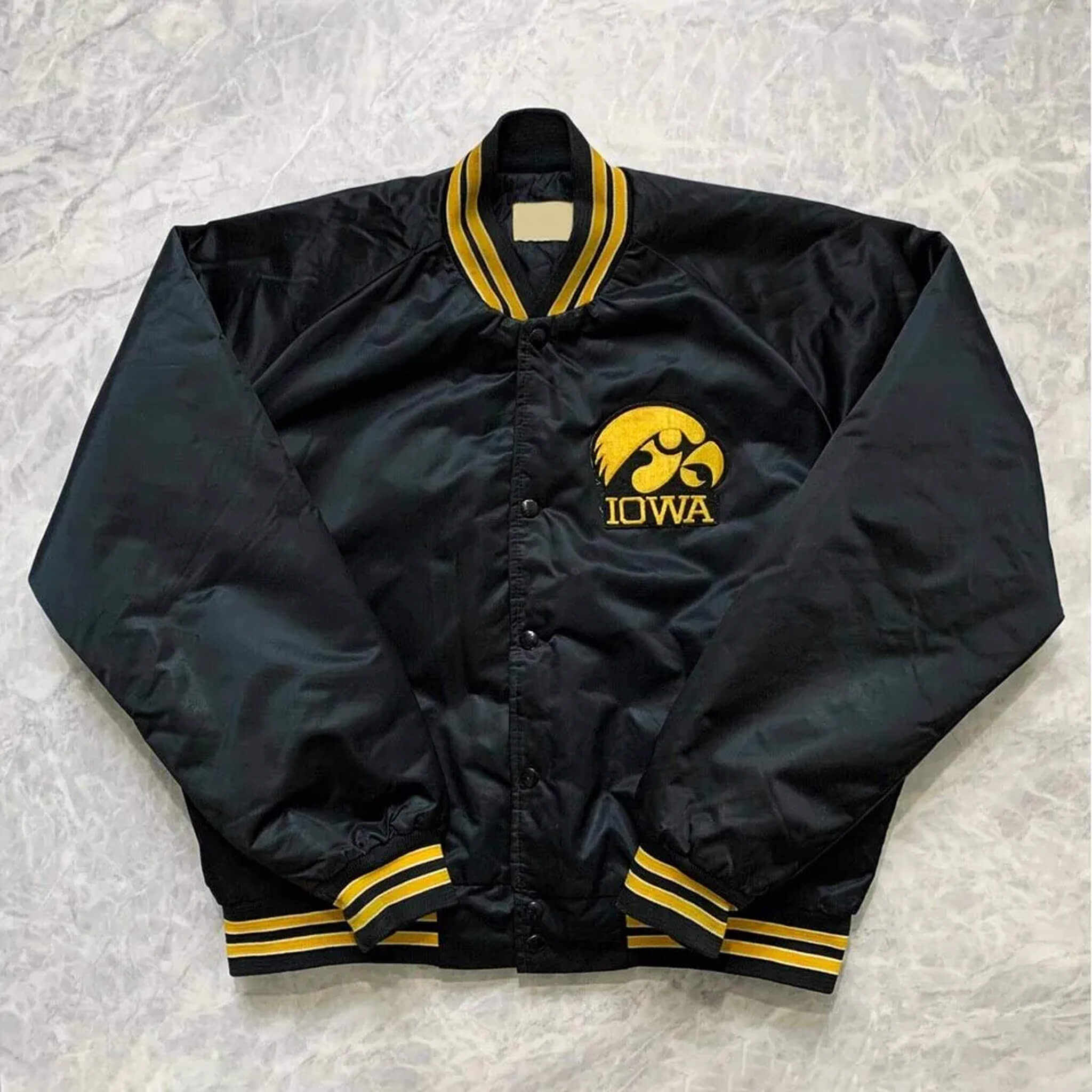 Vintage 90s Iowa Hawkeyes jacket with bold spellout logo and classic team colors.